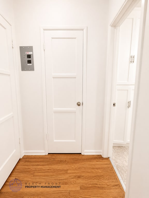 A white door with a keypad on the wall next to it.