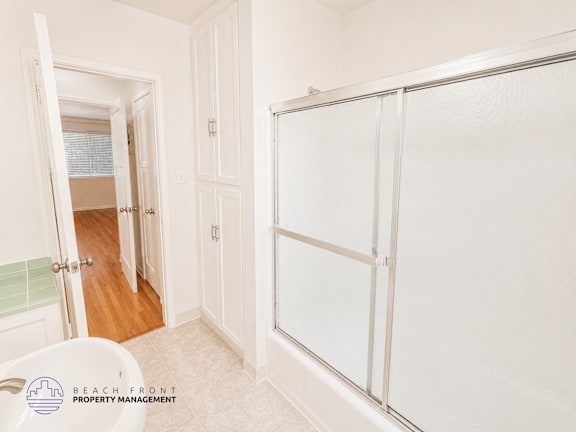 A white bathroom with a walk in shower and a toilet.