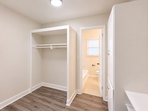 A small bedroom with a bunk bed and a doorway leading to another room.