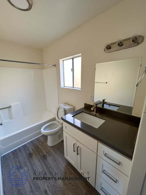 A bathroom with a toilet, sink, and mirror.