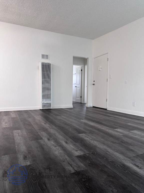 A room with a wood floor and white walls.