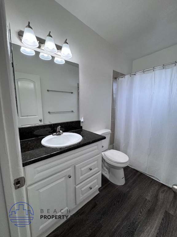 A bathroom with a sink, toilet, and mirror.