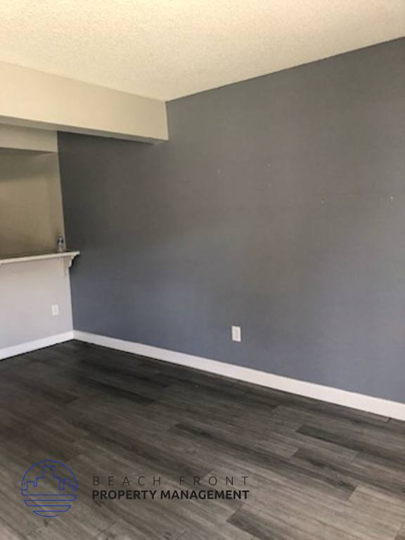 A room with a white fireplace and wooden flooring.