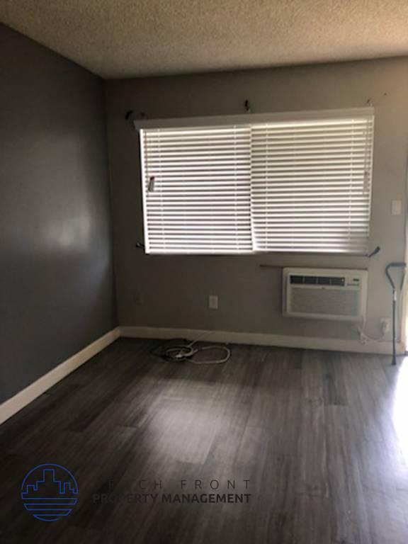 A room with a window and a floor lamp.