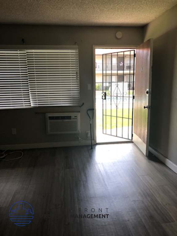 A room with a door and a window with blinds.