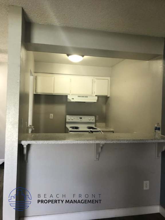 A small kitchen with a stove top oven and a microwave.