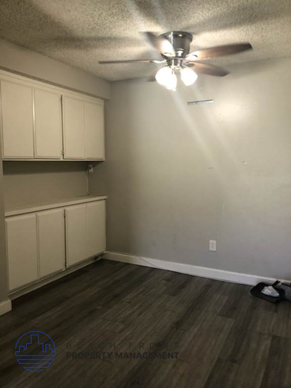 A room with a ceiling fan and wooden flooring.