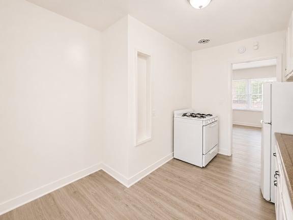 A white kitchen with a dishwasher and a refrigerator.