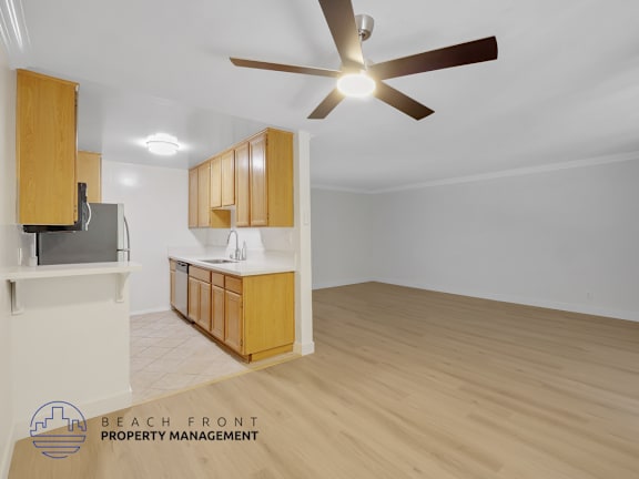 A spacious room with wooden flooring and a ceiling fan.