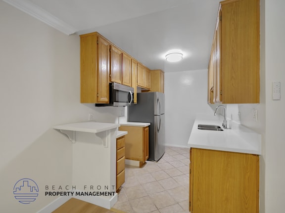 A kitchen with wooden cabinets and a refrigerator.
