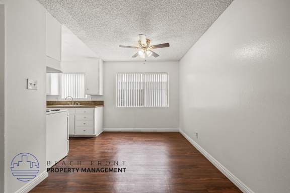 A room with a ceiling fan and wooden flooring.