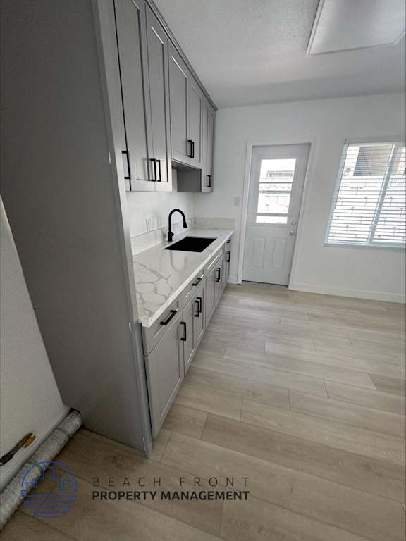 A kitchen with wooden floors and white walls.