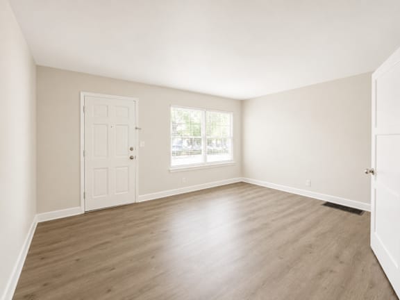 A room with a white door and a window with blinds.