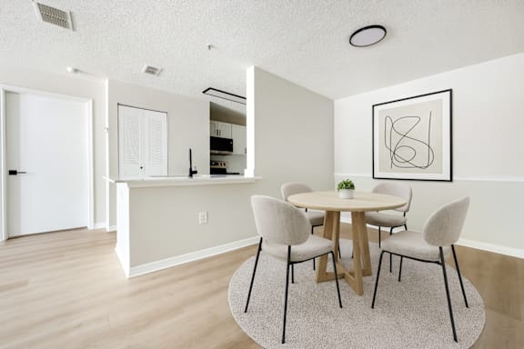 A dining room with a table and chairs.