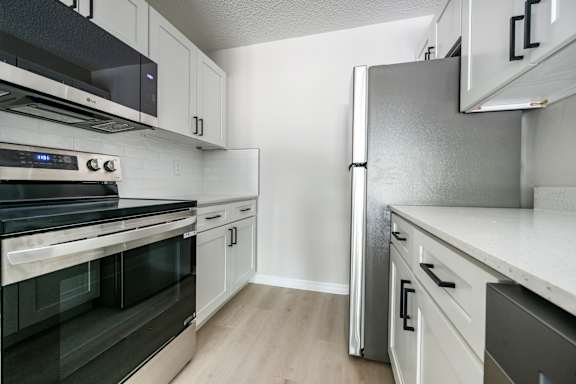 A kitchen with a stove, oven, and refrigerator.