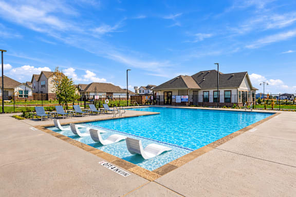 A swimming pool with lounge chairs and a sign that says "RELAX".