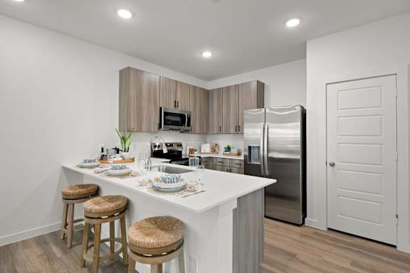 A kitchen with a white countertop and stainless steel appliances.