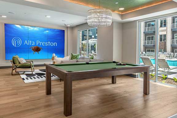 A pool table in a room with a sign that says Alta Preston.