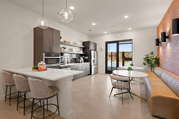 A modern kitchen with a bar area and a dining table.