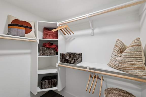 A white closet with a shelf and a hanging rod.