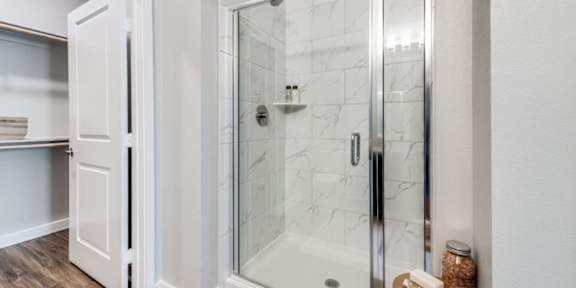 A white bathroom with a walk in shower.