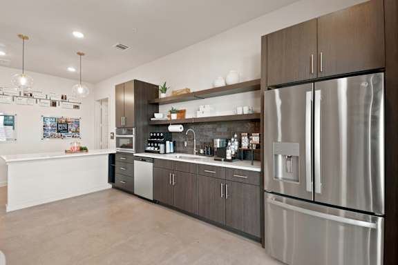 A modern kitchen with a stainless steel refrigerator and wooden cabinets.