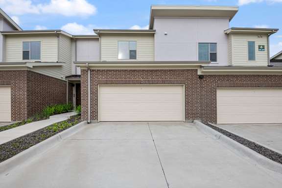 A two-story house with a garage door.