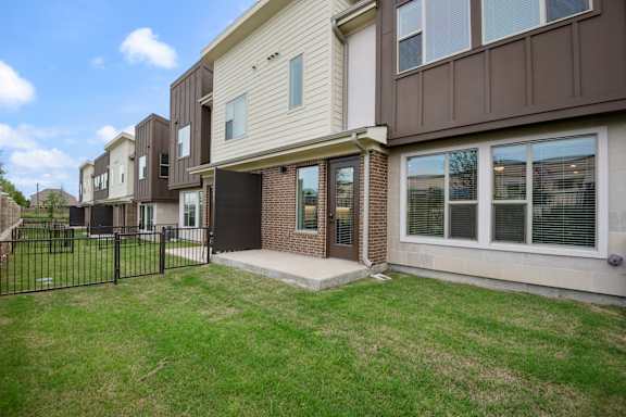 A row of houses with a black fence in front.