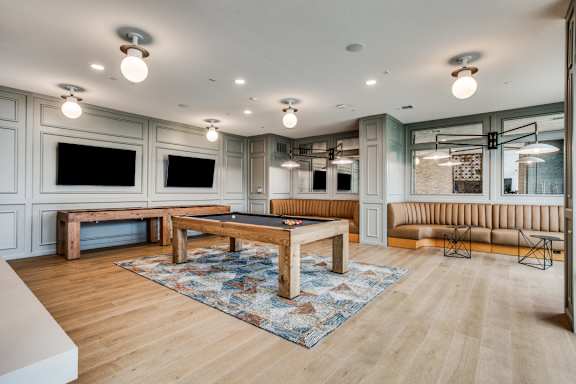 A modern living room with a wooden floor and a large rug.