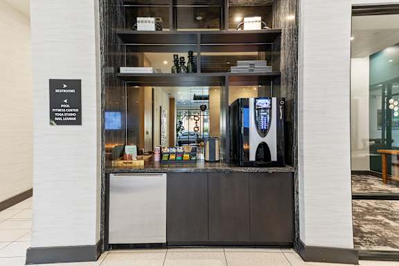 A black sign on a white pillar that says "Est. Rooms Fitness Center Pool Gym Lounge".