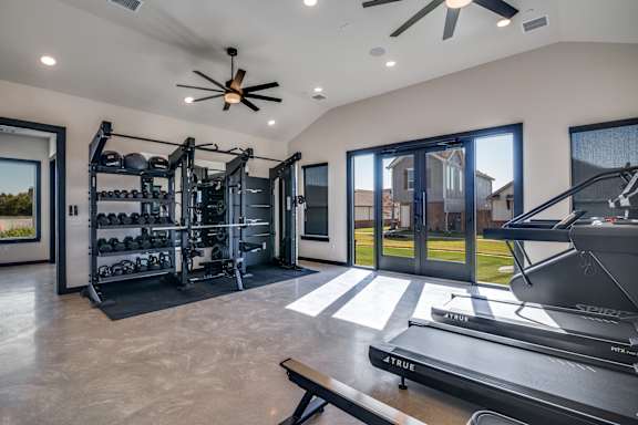 A modern home gym with a treadmill, weights, and exercise equipment.