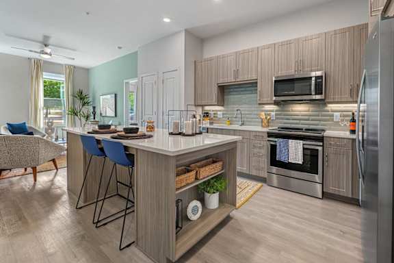 A modern kitchen with a bar area and a refrigerator.