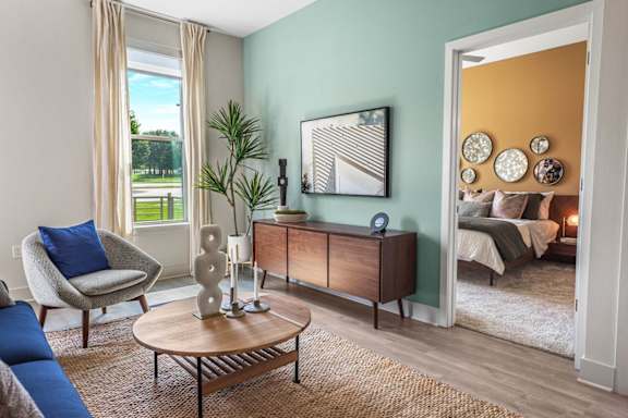 A living room with a chair, a table, and a cabinet.