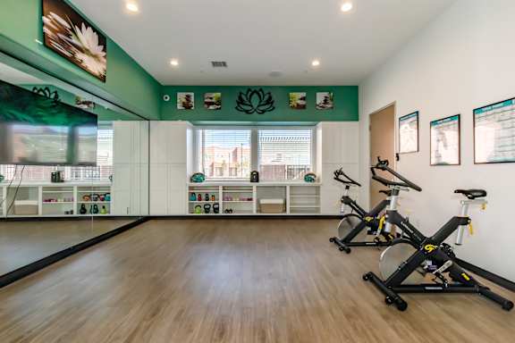 A room with exercise bikes and pictures on the wall.