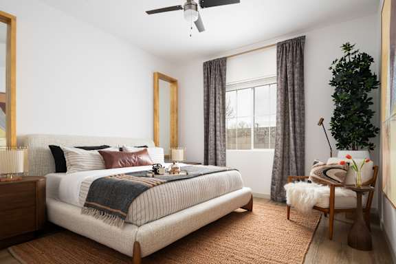 A bedroom with a large bed and a ceiling fan.