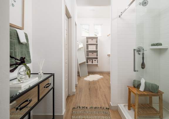 A bathroom with a shower, a vanity, and a bench.