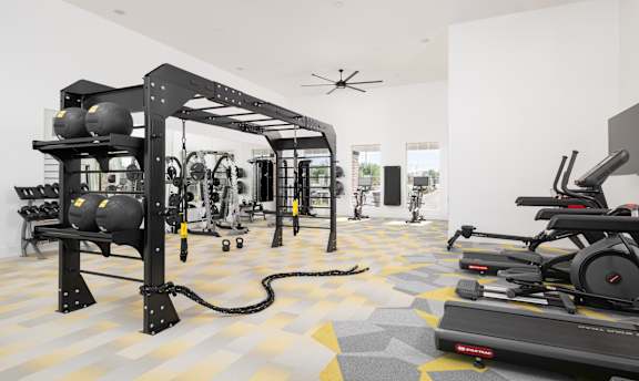 A gym with a treadmill, weights, and exercise equipment.