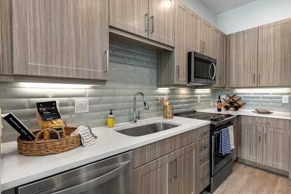 A modern kitchen with wooden cabinets and stainless steel appliances.