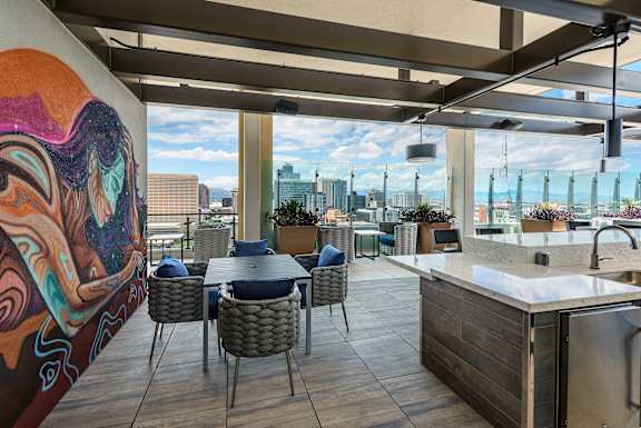A modern kitchen and dining area with a view of the city.