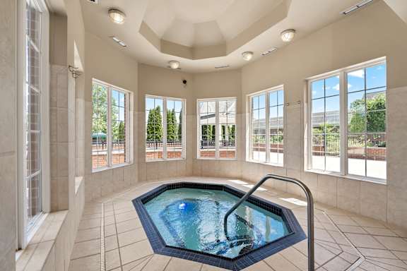 an indoor jacuzzi in a large room with windows
