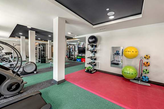 A gym with a red mat in the middle of the room.