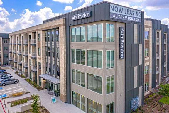 A multi-story building with a sign that reads "Now Leasing" is shown.