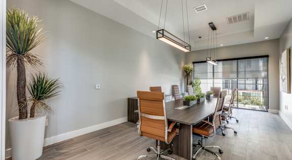 A conference room with a long table and chairs.