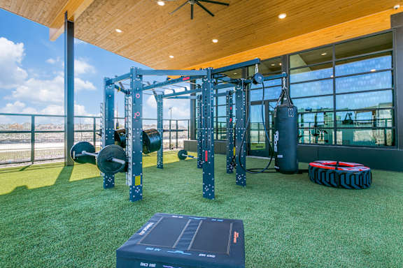 A gym with a green floor and a wooden ceiling.