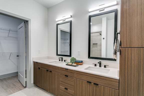 A bathroom with a white countertop and brown cabinets.