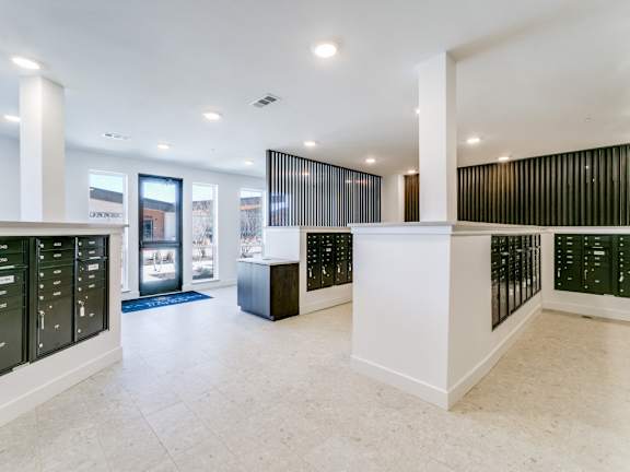 A white reception area with a blue rug and a white pillar.