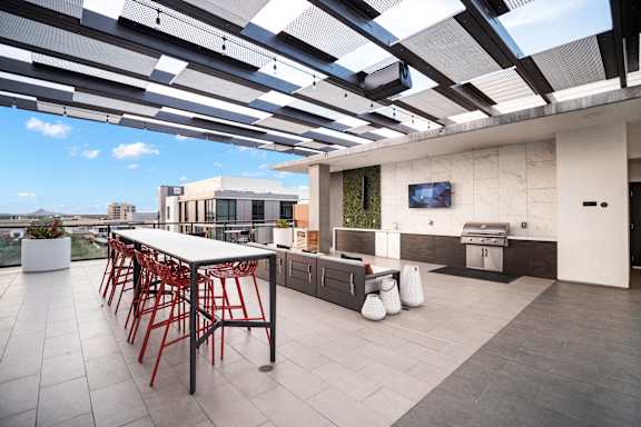 A patio with a table and chairs is covered by a roof.