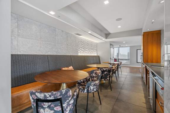 A modern dining area with a wooden table and chairs.