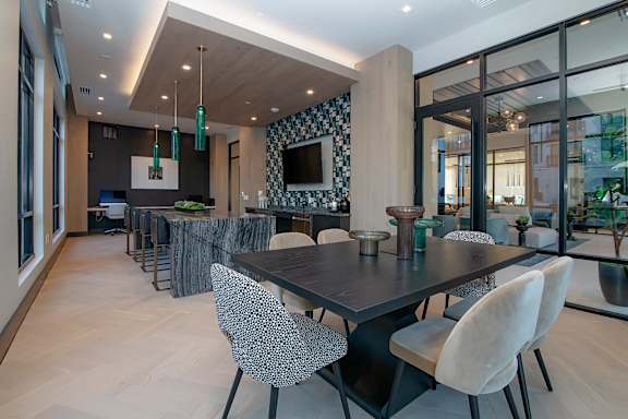 A modern dining room with a black table and chairs.