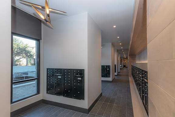 A long hallway with a black mailbox on the wall.